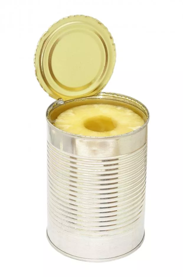 Photo of opened metal can with pineapple.