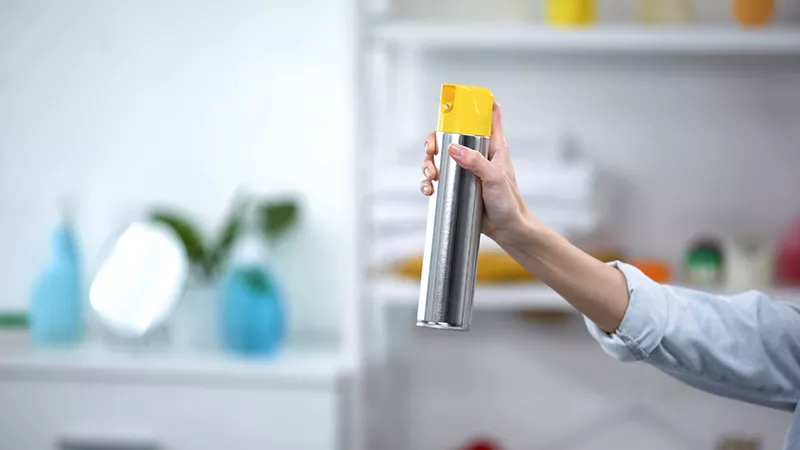 Image of hand holding aerosol cleaner