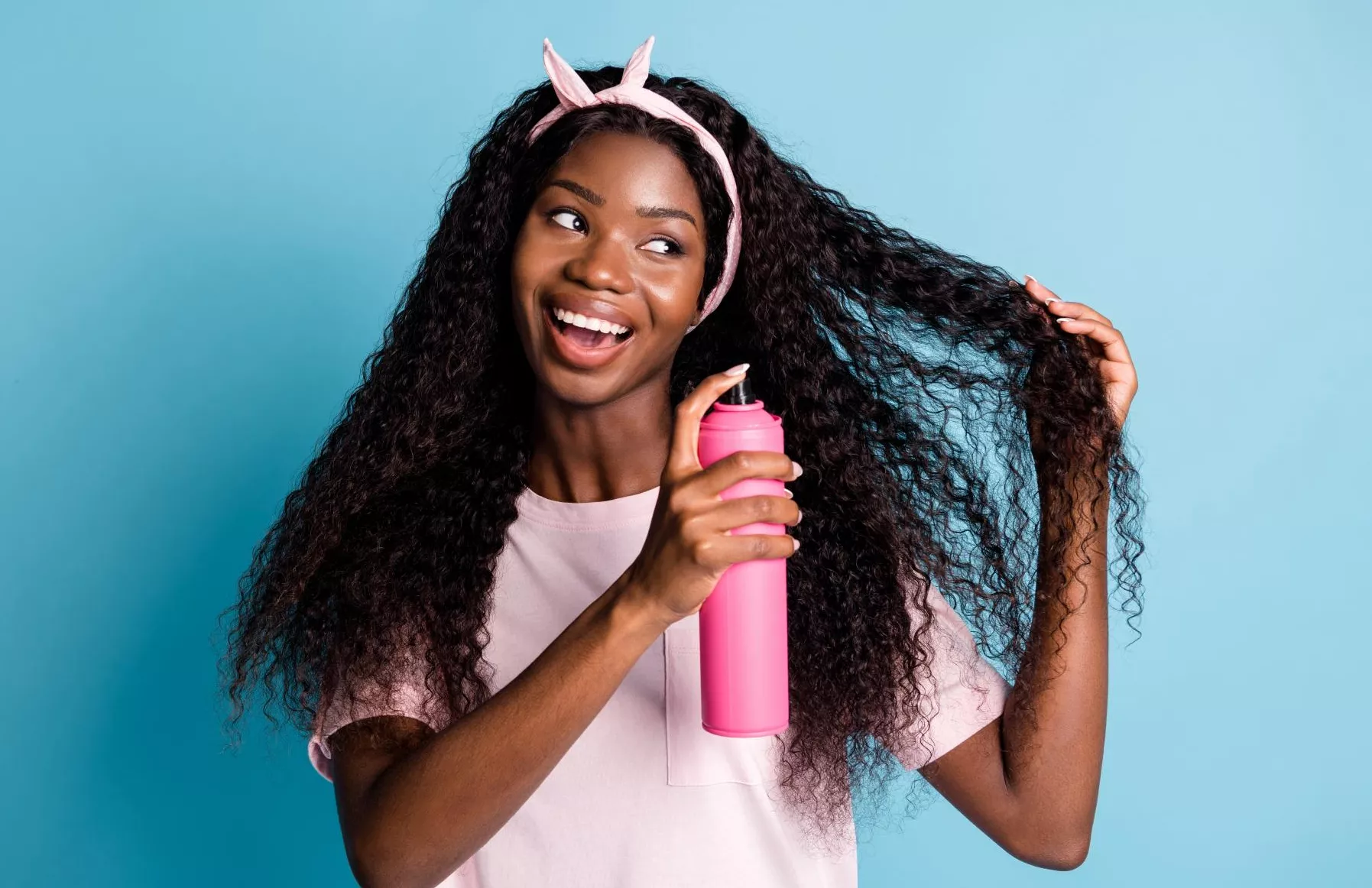 Photo of woman using aerosol product in her long hair