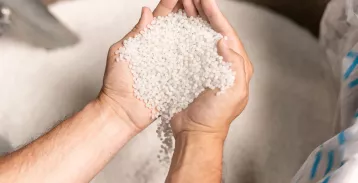 Hands sifting through plastic pellets