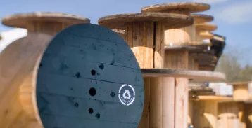 Large wood reels outdoors, stacked on top of one another