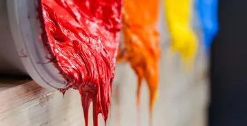 Thick red material drips from a container