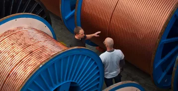Two men talking beside industrial-sized reels