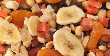 Dried bananas, raisins, nuts, and other snacks mixed together