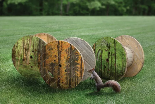 Three wooden reels in a grassy field.